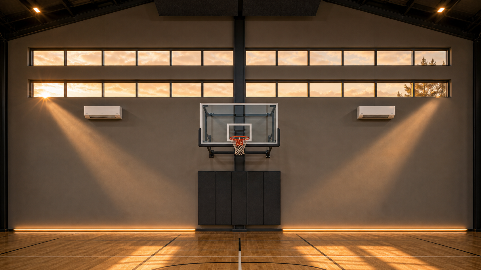 AI-rendered interior elevation of the west gym hero wall at golden hour — symmetrical composition centered on a partially exposed PEMB structural column, two 16-foot module clerestory runs subdivided into 4-foot sub-modules in two horizontal rows, central no-glass field with a 72-inch glass commercial backboard and breakaway rim on a dark steel hoop spine subframe, 8-foot soft charcoal athletic wall pad, two symmetrical white mini-splits beneath the lower clerestory row, polished hardwood gym floor with subtle volleyball court lines, warm sunset wedges of light pouring through the clerestories