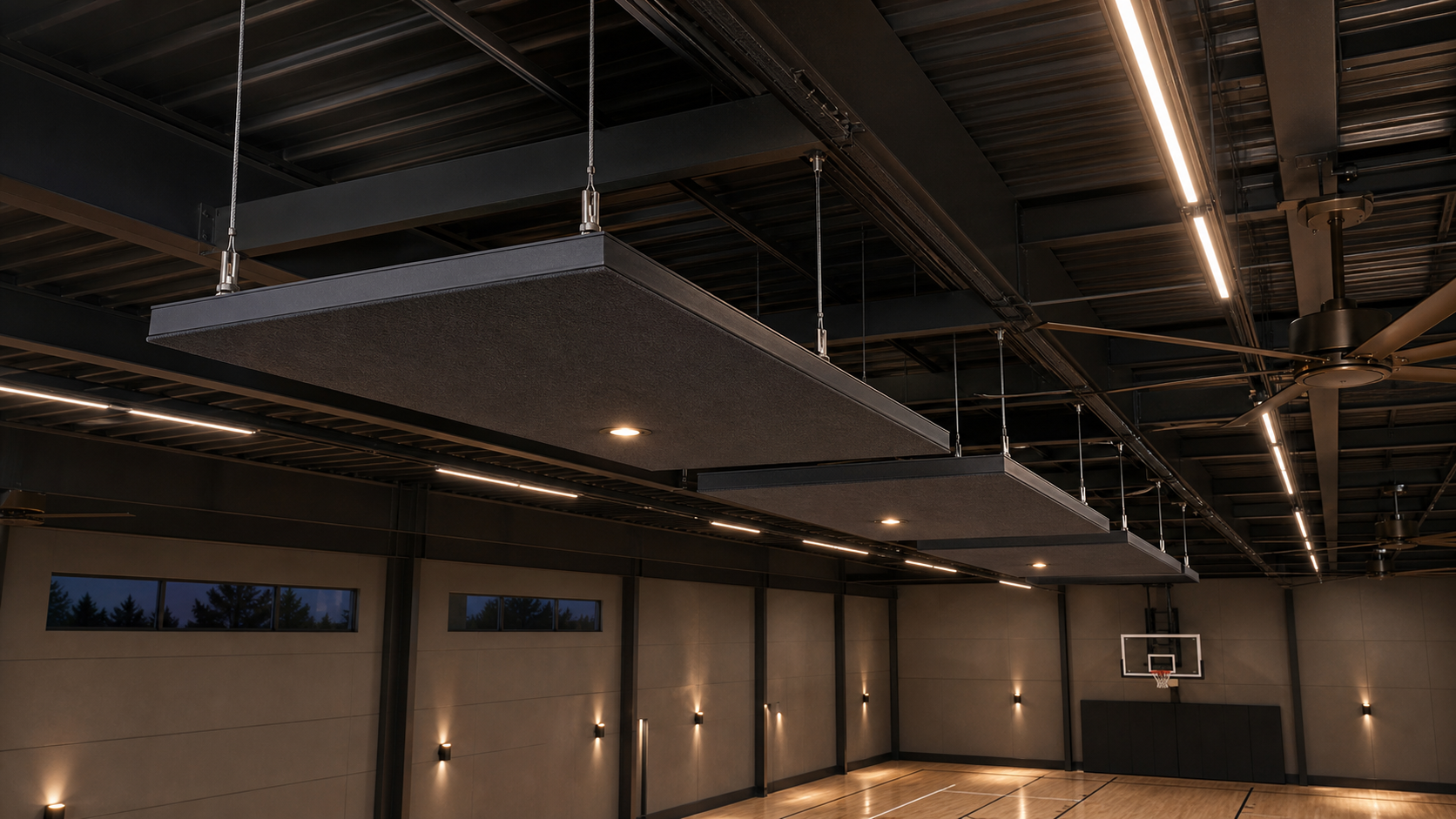 AI-rendered upward section view of three suspended 4-by-8 foot site-fabricated acoustic cloud modules — dark-charcoal fabric-wrapped mineral wool with industrial galvanized U-channel edges, hung on stainless aircraft cables from PEMB roof purlins with a clear 12-24 inch air gap to the dark-charcoal structural roof deck, integrated low-profile LED slim-pots in the edges, adjacent linear LED run and edge of one destratification fan visible in the same N-S infrastructure band